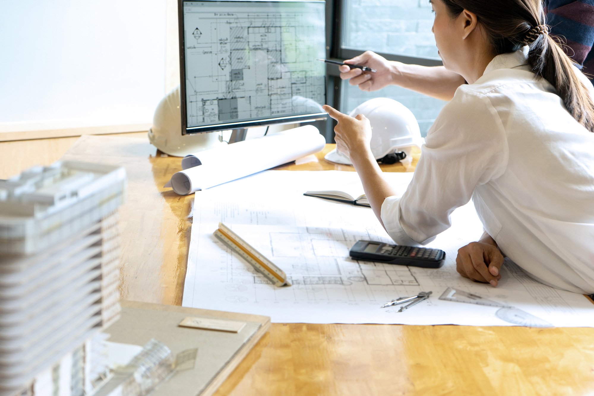 Architekten mit gedrucktem Plan Besprechung am Bildschirm