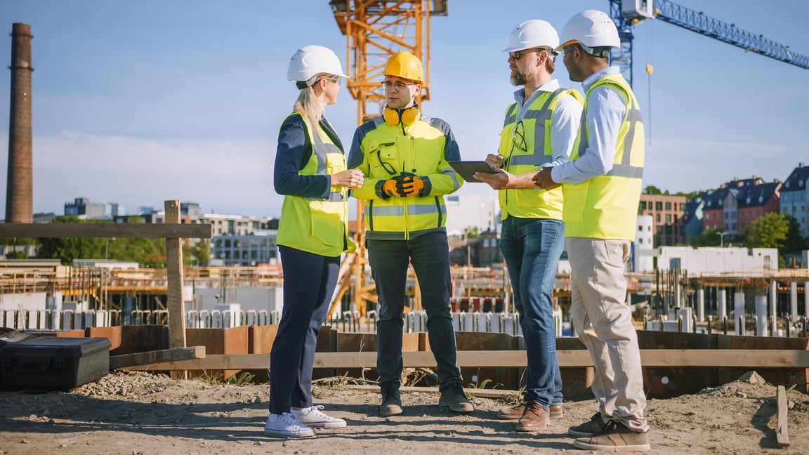 stock-photo-diverse-team-of-specialists-use-tablet-computer-on-construction-site-real-estate-building-project-181737