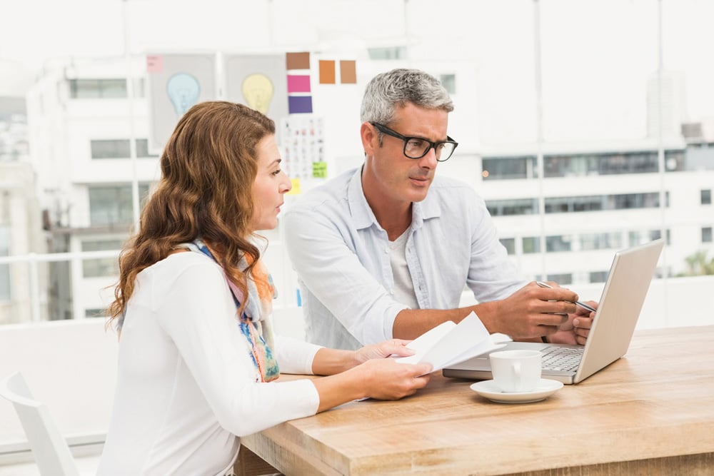 stock-photo-two-casual-designers-working-with-laptop-in-the-office-307381220