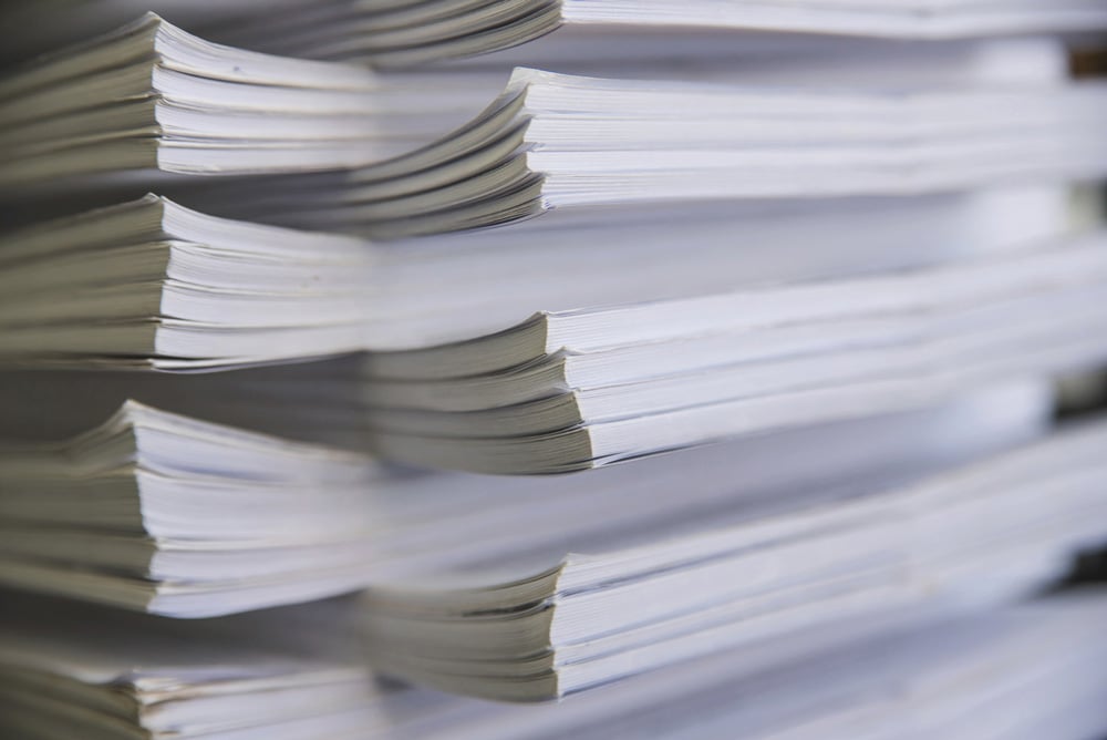 stock-photo-close-up-of-man-putting-stack-of-paper-in-printing-machine-at-publishing-shop-copy-space-2221146511