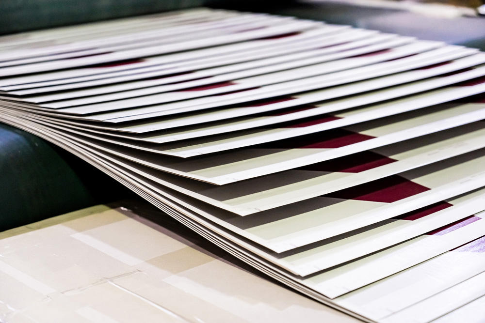 stock-photo-printing-at-high-speed-on-offset-machine-label-rolled-up-printing-out-group-of-objects-2334221023